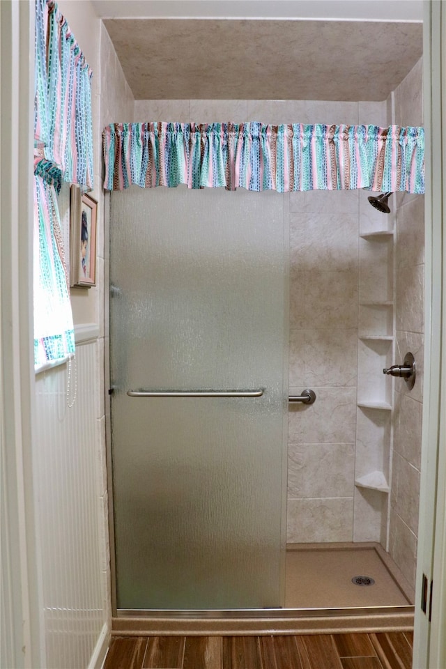 bathroom featuring an enclosed shower and hardwood / wood-style flooring