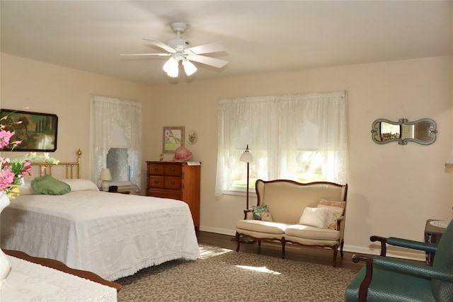 bedroom with dark hardwood / wood-style flooring and ceiling fan