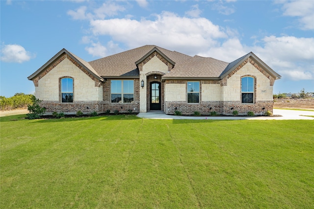 french country home featuring a front lawn