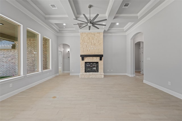 unfurnished living room with crown molding, a fireplace, ceiling fan, coffered ceiling, and beam ceiling