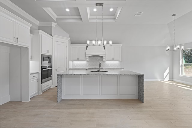 kitchen with hanging light fixtures, white cabinets, light stone counters, and stainless steel appliances