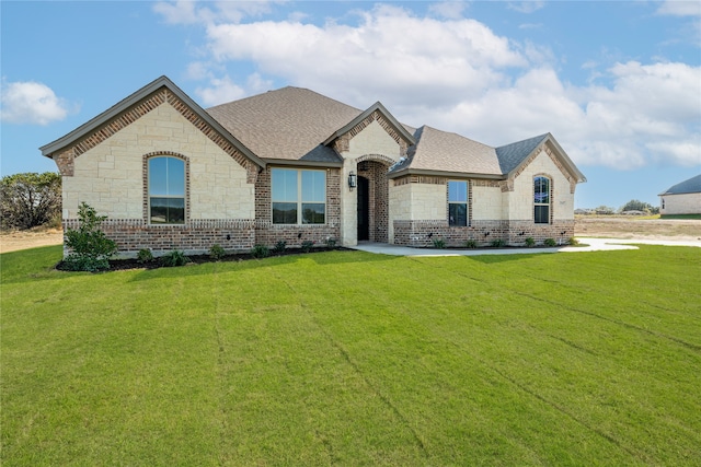 french country home featuring a front lawn