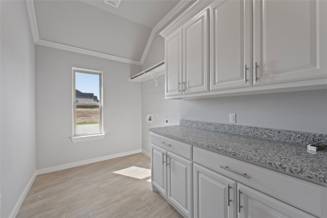 laundry room with ornamental molding, electric dryer hookup, light wood-type flooring, and cabinets