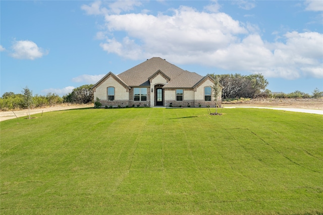 french country inspired facade featuring a front yard