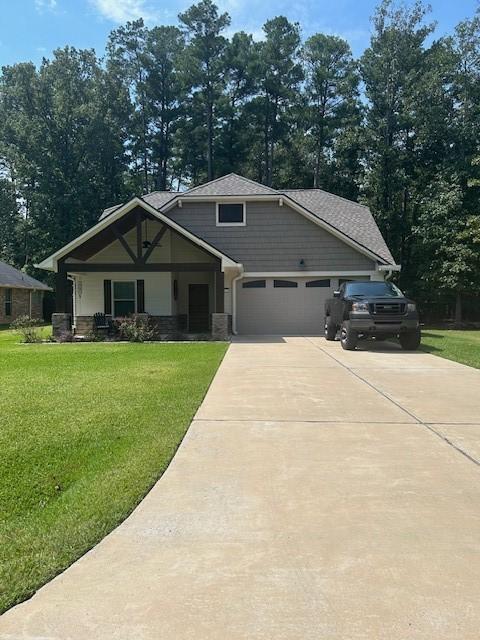 craftsman inspired home with a garage, a porch, and a front lawn