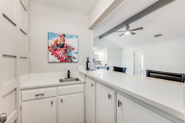 kitchen featuring sink, white cabinetry, vaulted ceiling with beams, and ceiling fan