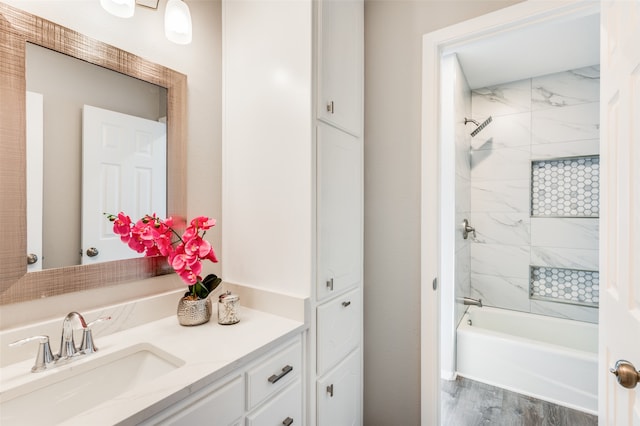 bathroom with vanity, hardwood / wood-style floors, and tiled shower / bath combo