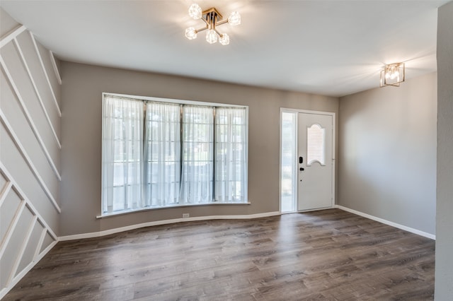 foyer entrance featuring an inviting chandelier and dark wood-type flooring