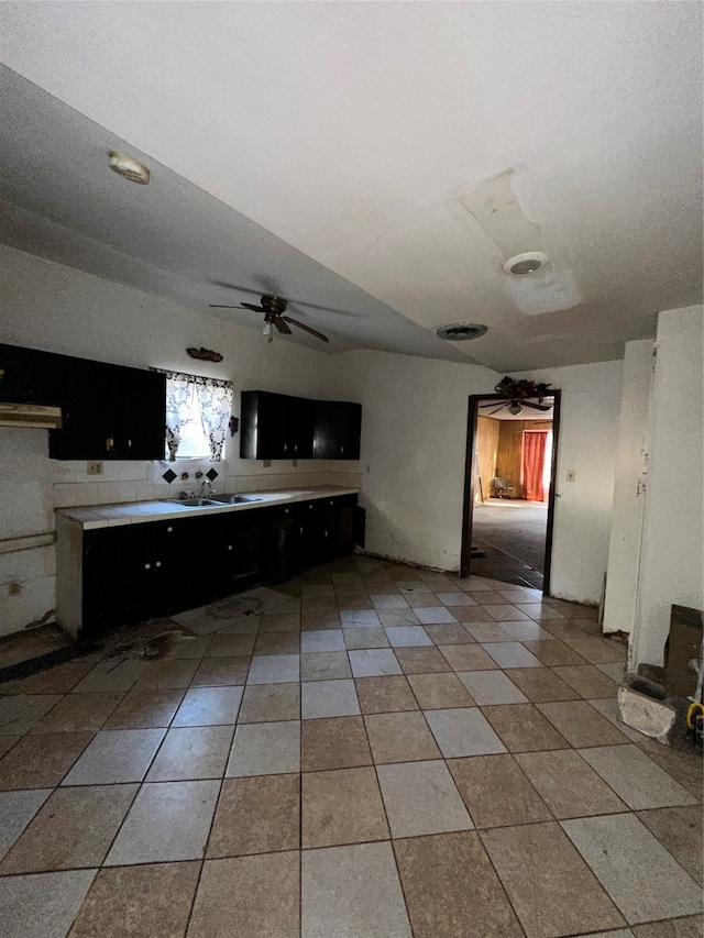 kitchen featuring range hood, sink, light tile patterned floors, and ceiling fan