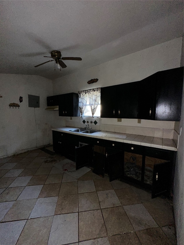 kitchen with tile countertops, sink, a textured ceiling, and ceiling fan