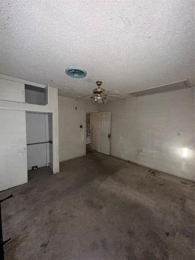 interior space featuring a textured ceiling, carpet flooring, and ceiling fan