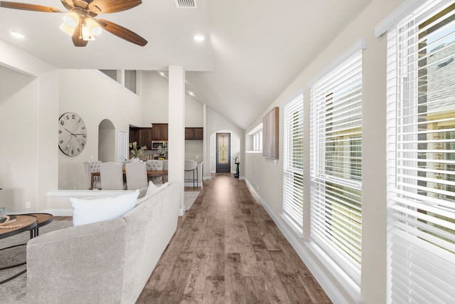 hallway with light hardwood / wood-style flooring and high vaulted ceiling