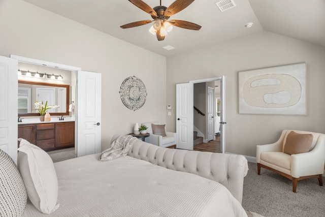 carpeted bedroom with ceiling fan, sink, connected bathroom, and vaulted ceiling