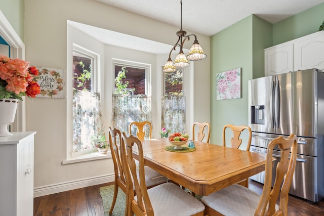 dining area with dark hardwood / wood-style floors and a textured ceiling