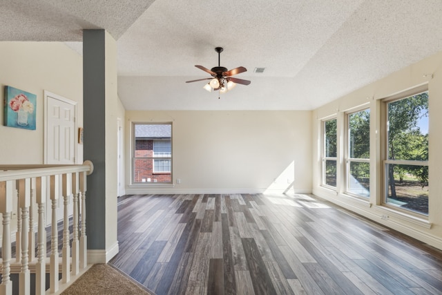 empty room featuring ceiling fan, wood-type flooring, and a textured ceiling