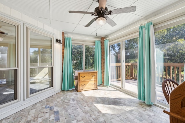 unfurnished sunroom with ceiling fan