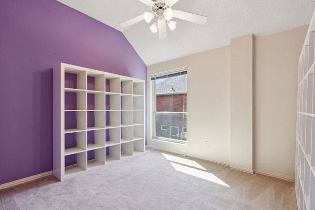 unfurnished bedroom with lofted ceiling, a textured ceiling, carpet flooring, and ceiling fan