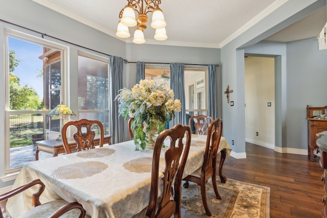 dining room featuring ornamental molding, dark wood-type flooring, a textured ceiling, and an inviting chandelier