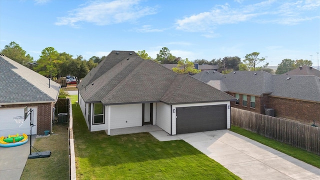 view of front of home with a front lawn, central AC unit, and a garage