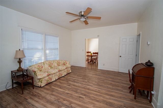 living area with dark wood-type flooring and ceiling fan