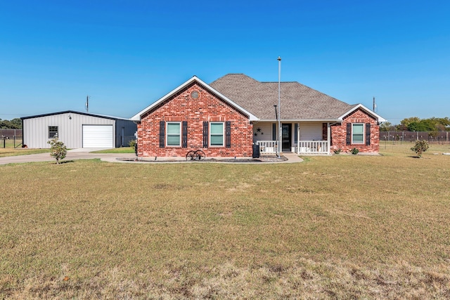 ranch-style home featuring a garage, a front lawn, and an outbuilding