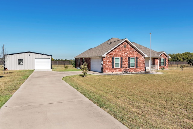 single story home with a garage, a front yard, and an outbuilding