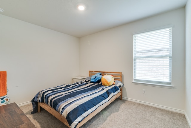 bedroom featuring light carpet and multiple windows