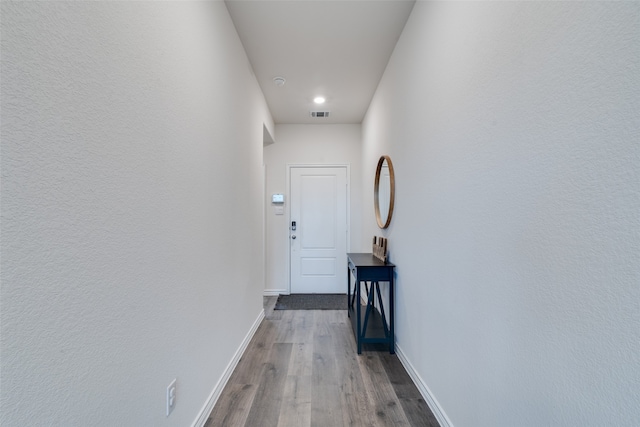 corridor with hardwood / wood-style flooring