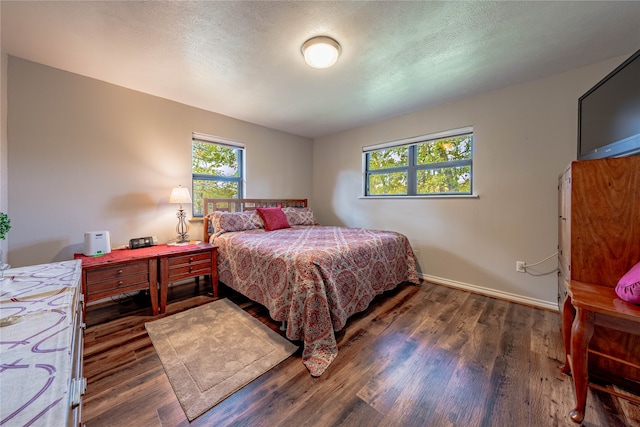 bedroom featuring a textured ceiling and dark hardwood / wood-style flooring