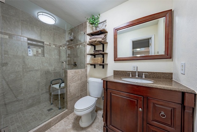 bathroom with a shower with door, vanity, a textured ceiling, and toilet