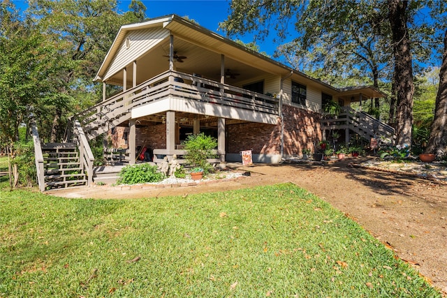 back of property featuring a wooden deck and a lawn