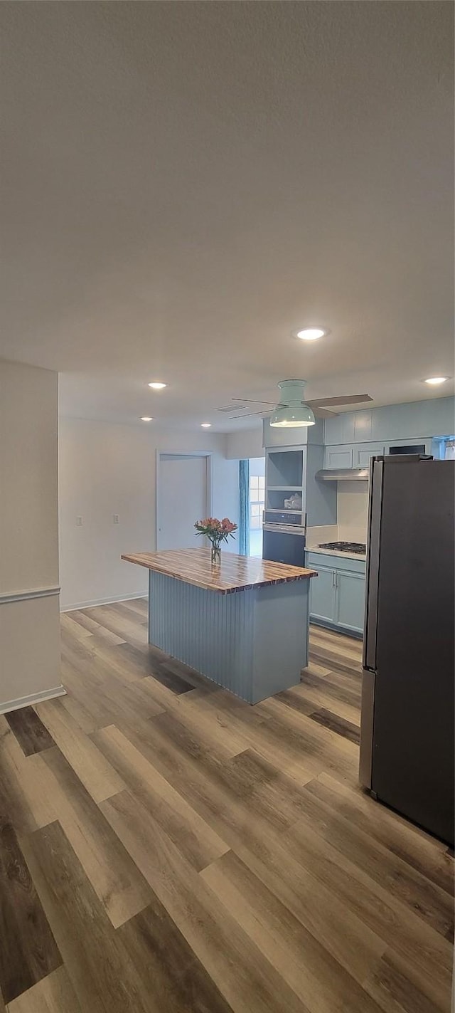 kitchen featuring cooktop, light hardwood / wood-style flooring, stainless steel refrigerator, and a kitchen island