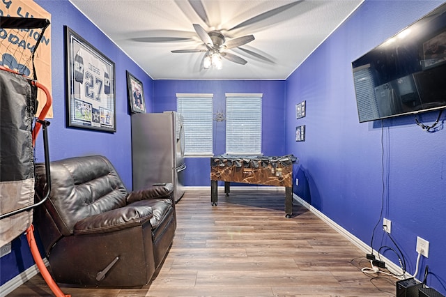 living area featuring ceiling fan and light hardwood / wood-style flooring