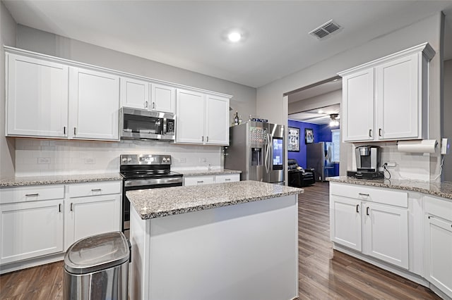 kitchen with appliances with stainless steel finishes, dark hardwood / wood-style floors, and white cabinets