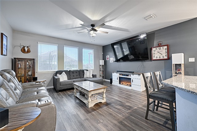 living room featuring ceiling fan and dark hardwood / wood-style flooring