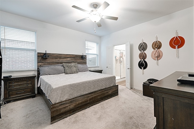 carpeted bedroom featuring ensuite bath and ceiling fan