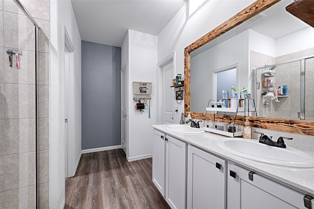 bathroom featuring a shower with door, vanity, and hardwood / wood-style floors