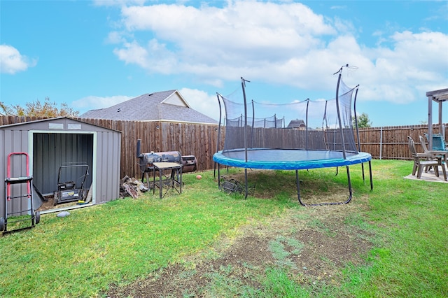 view of yard with a storage shed and a trampoline