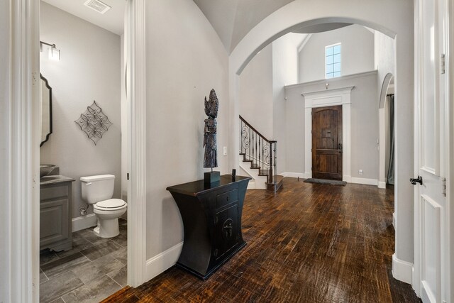 foyer with dark hardwood / wood-style floors and vaulted ceiling