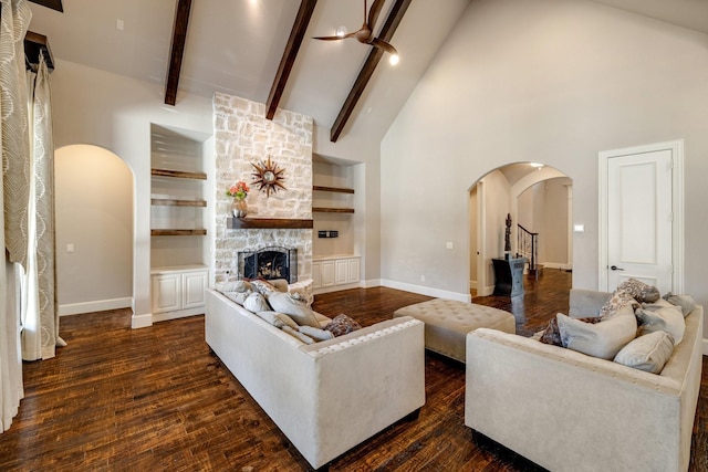 1240 Concho Trl, Prosper, TX 75078 - living room with arched walkways, high vaulted ceiling, a fireplace, dark wood-style flooring, and built in shelves