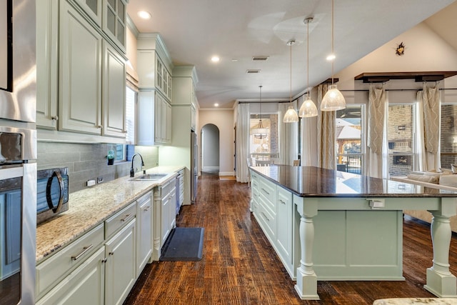 1240 Concho Trl, Prosper, TX 75078 - kitchen with arched walkways, a kitchen island, tasteful backsplash, recessed lighting, and dark stone countertops