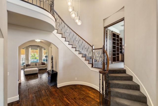 staircase featuring hardwood / wood-style flooring and a high ceiling