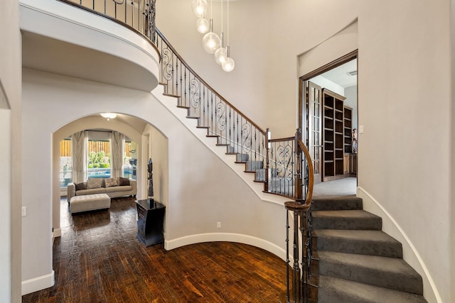 1240 Concho Trl, Prosper, TX 75078 - stairs with arched walkways, wood finished floors, and a high ceiling