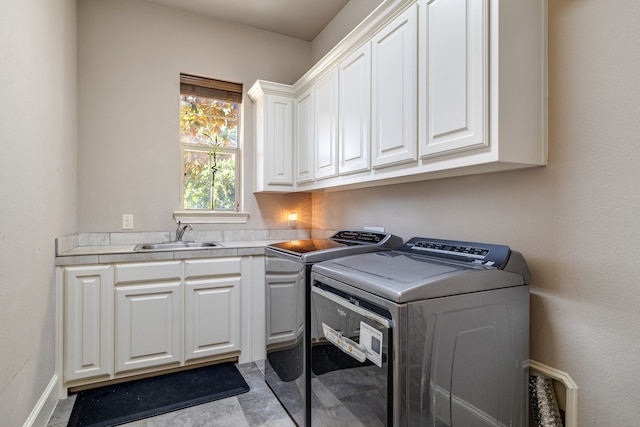 laundry area featuring cabinets, washer and dryer, and sink