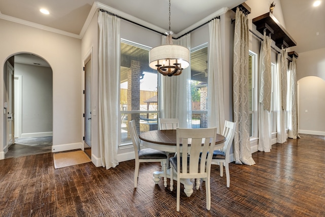 dining room with dark wood-type flooring, an inviting chandelier, and crown molding