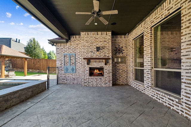 view of patio / terrace with an outdoor brick fireplace and ceiling fan