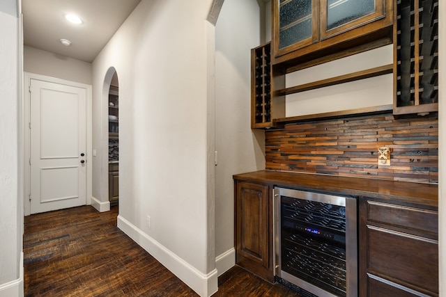 bar with dark hardwood / wood-style floors, beverage cooler, backsplash, and wood counters