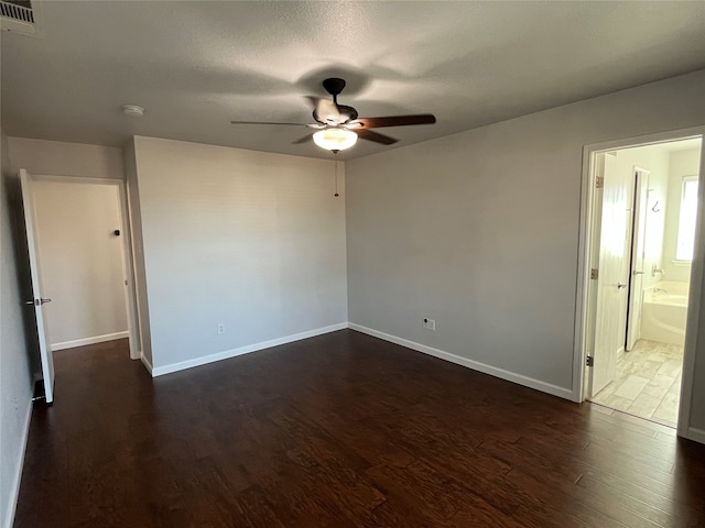 spare room with dark hardwood / wood-style floors, a textured ceiling, and ceiling fan