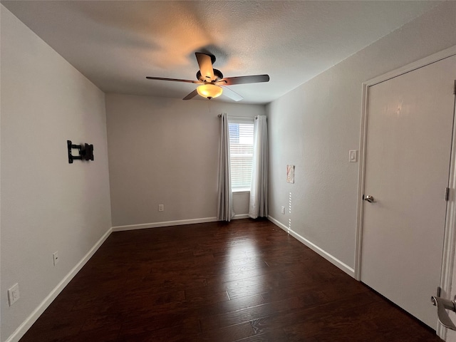 unfurnished room with ceiling fan, a textured ceiling, and dark hardwood / wood-style floors