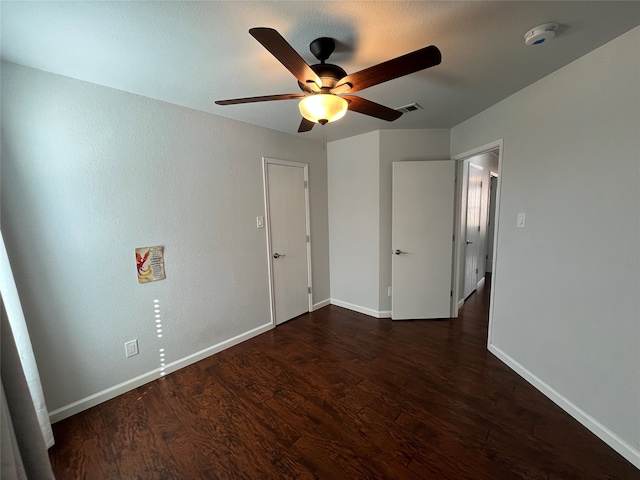 unfurnished bedroom with dark wood-type flooring and ceiling fan